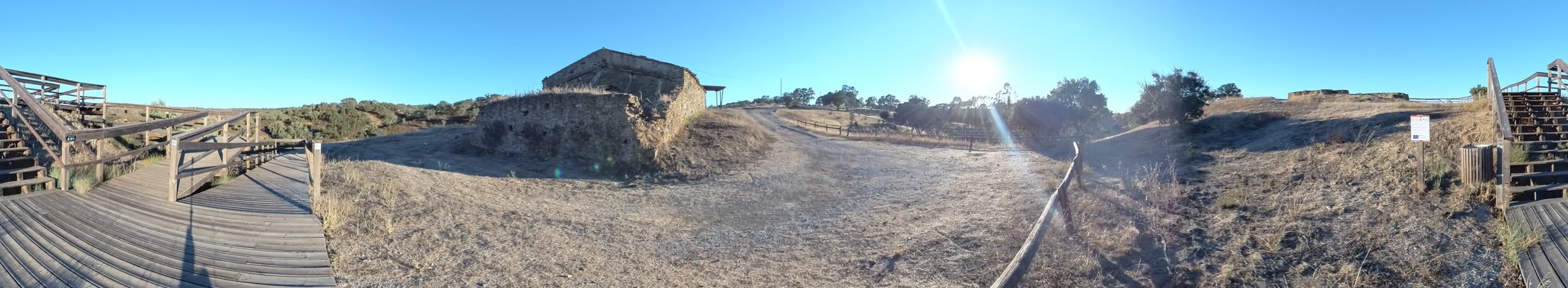 360° panorama of Mesas do Castelinho in the late afternoon: wooden boardwalk, ruined wall and the low sun in the west